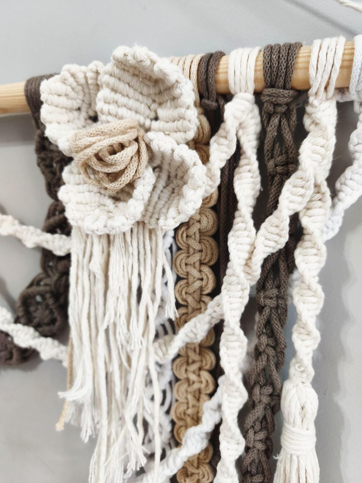 Close up of handmade three dimensional macrame flower in ivory cotton cord