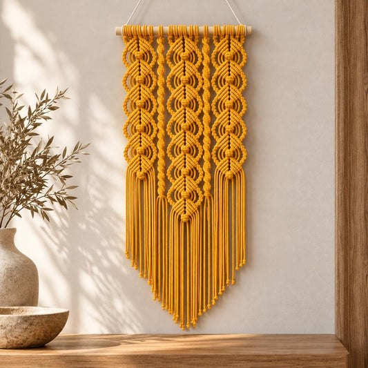 Decorative yellow macrame wall art styled against a warm white wall