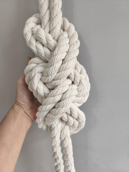 Close up of handmade rope knot wall hanging showing thick cotton cord texture