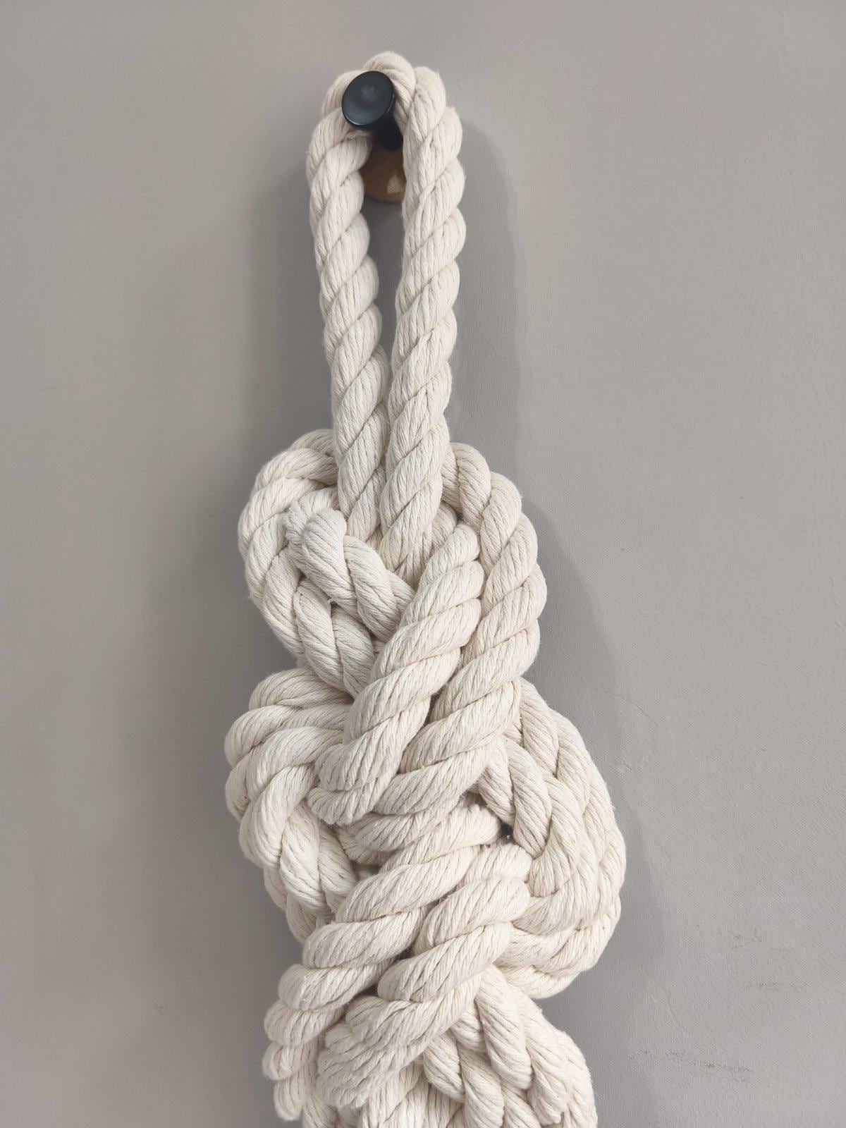 Close up of sculptural macrame knot made from thick twisted cream cotton rope