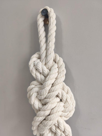 Close up of sculptural macrame knot made from thick twisted cream cotton rope