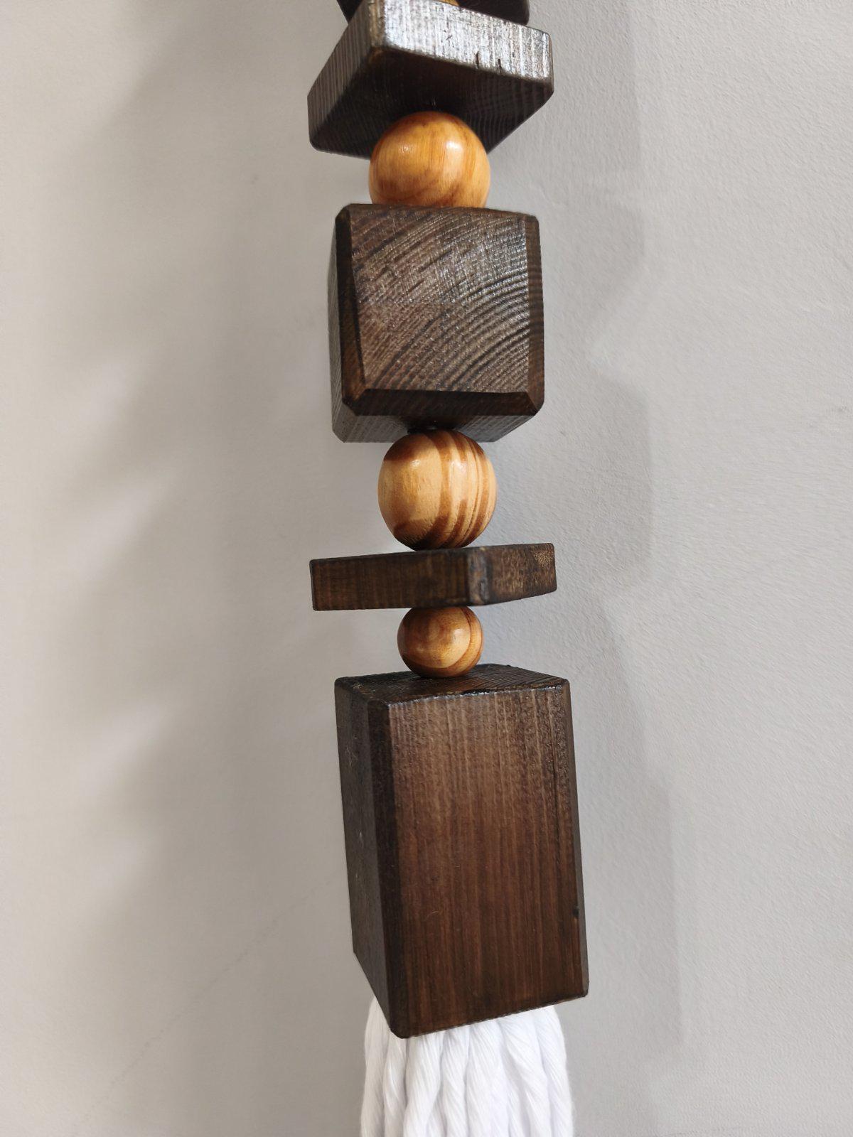 Close up of dark wood geometric beads on handmade macrame wall hanging
