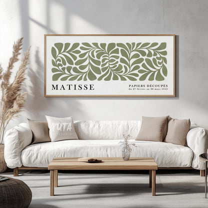 Framed sage green Matisse botanical print displayed above a sofa with pampas grass.