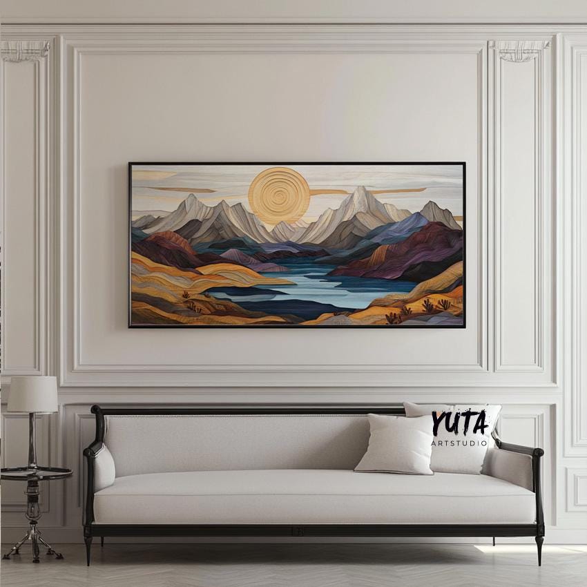 Wide pastel mountain landscape art in a black frame, shown above a three-seat sofa for scale