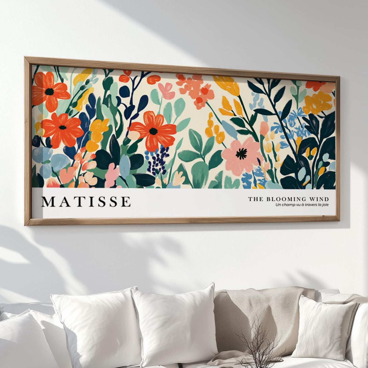 Framed Matisse-inspired wildflower print above a neutral sofa with white cushions.