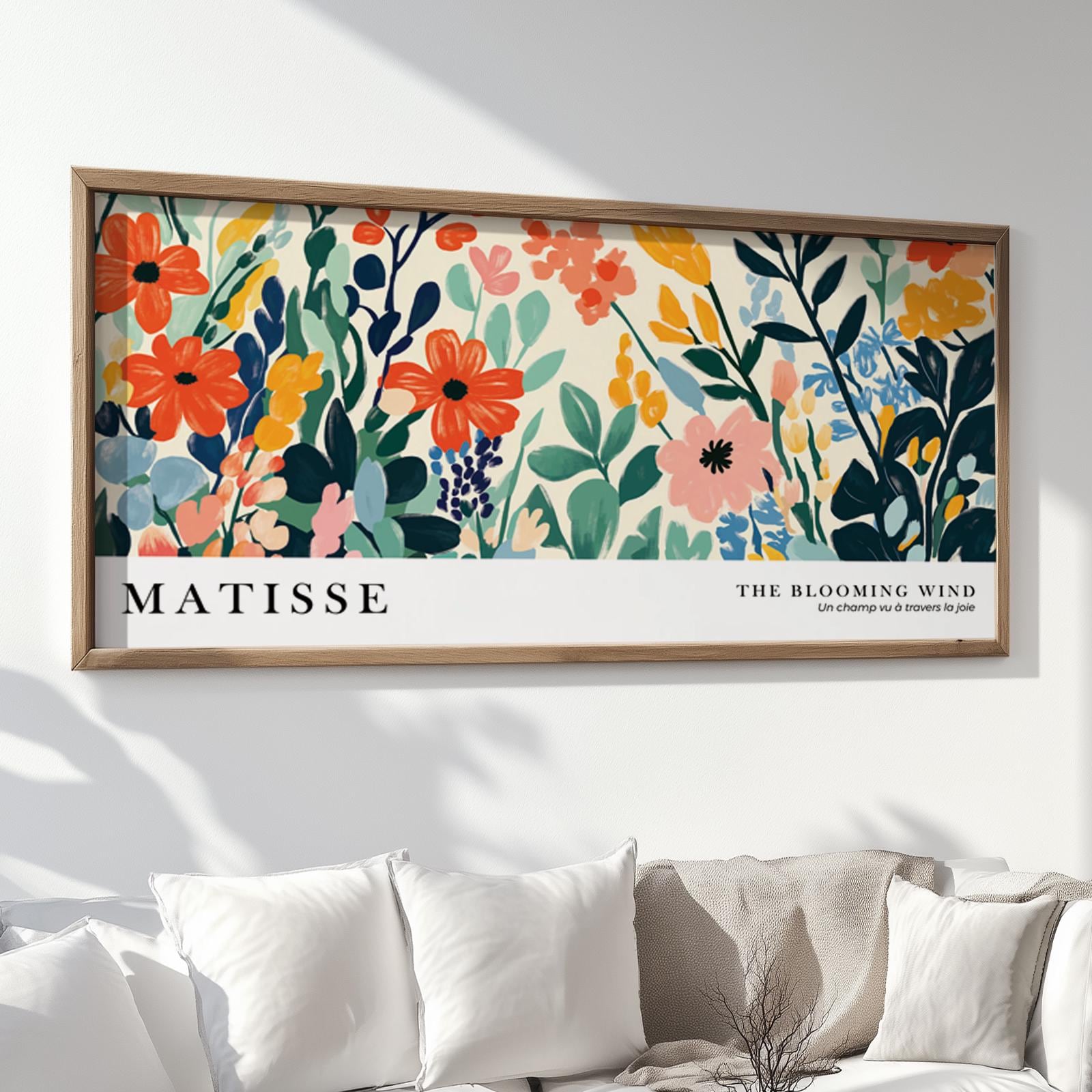 Framed Matisse-inspired wildflower print above a neutral sofa with white cushions.