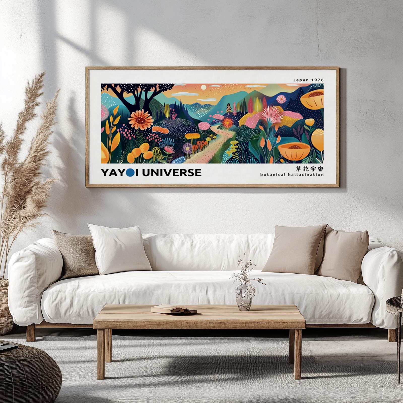 Framed abstract botanical mountain print in Yayoi Kusama style displayed above a white sofa.