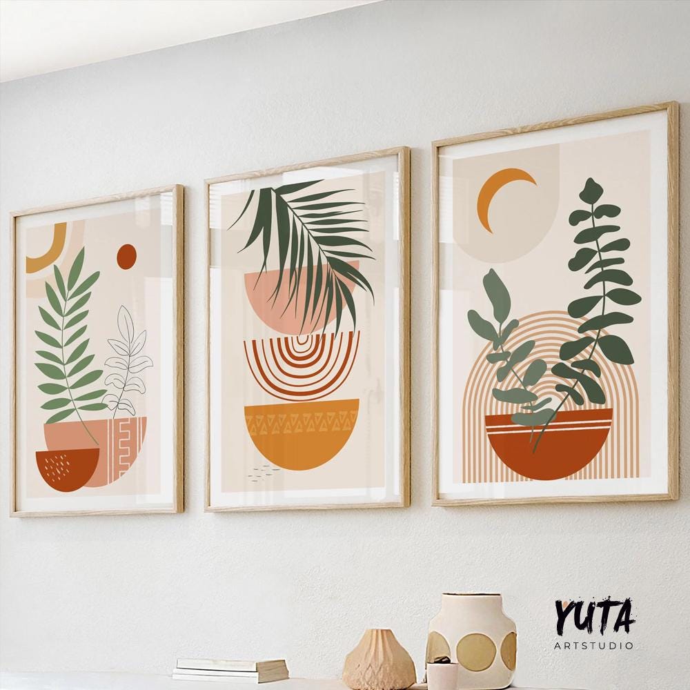 Trio of framed terracotta and beige botanical prints hung above a light sofa