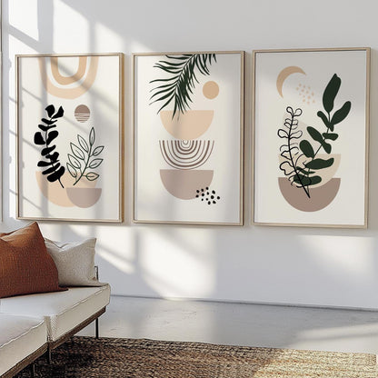 Three abstract botanical boho prints in natural frames displayed above a cream sofa.