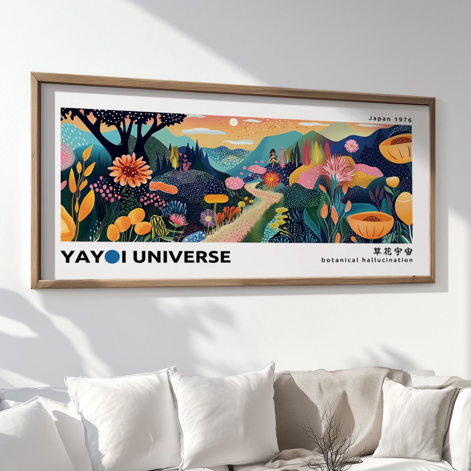 Framed abstract botanical mountain print in large size displayed above white cushions