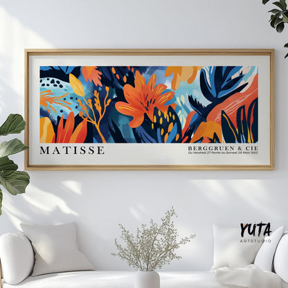 Vibrant tropical floral artwork in a light wood frame hung above a minimalist sofa.