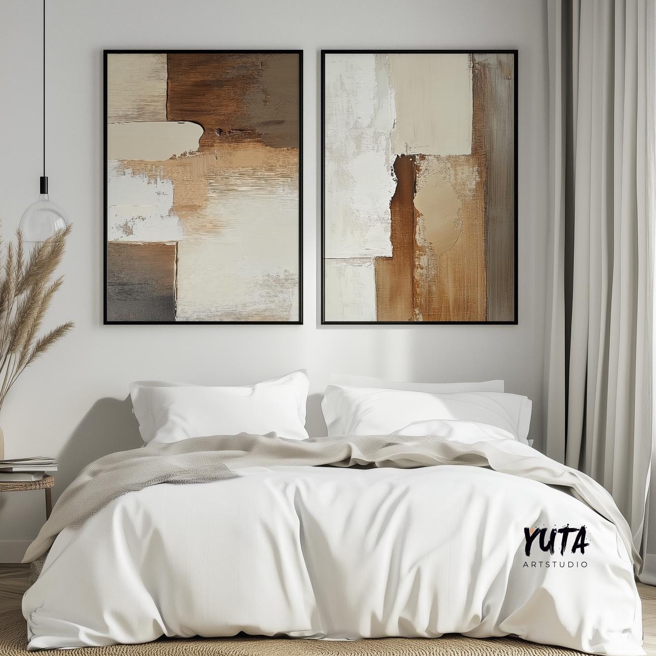 Neutral abstract art prints in black frames displayed above a white bed with pillows