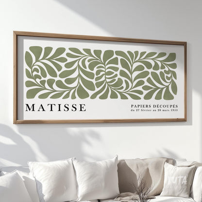 Framed abstract sage green Matisse print in minimalist packaging-ready display above cushions