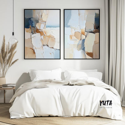 Textured abstract diptych in black frames centered above a white bed with beige throw