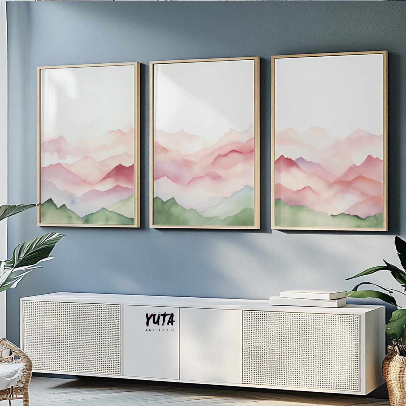 Trio of pastel abstract mountain prints in light wood frames above a white sideboard