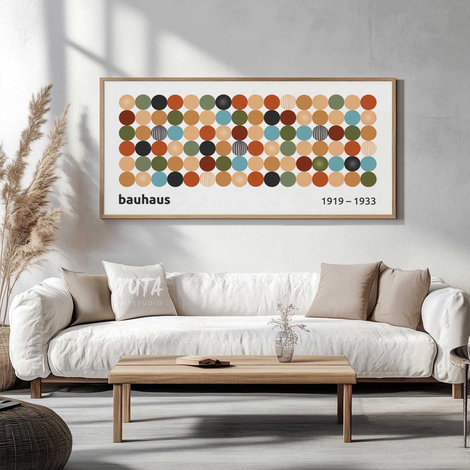 Geometric Bauhaus print with colorful circular motifs in a light wood frame above a sofa