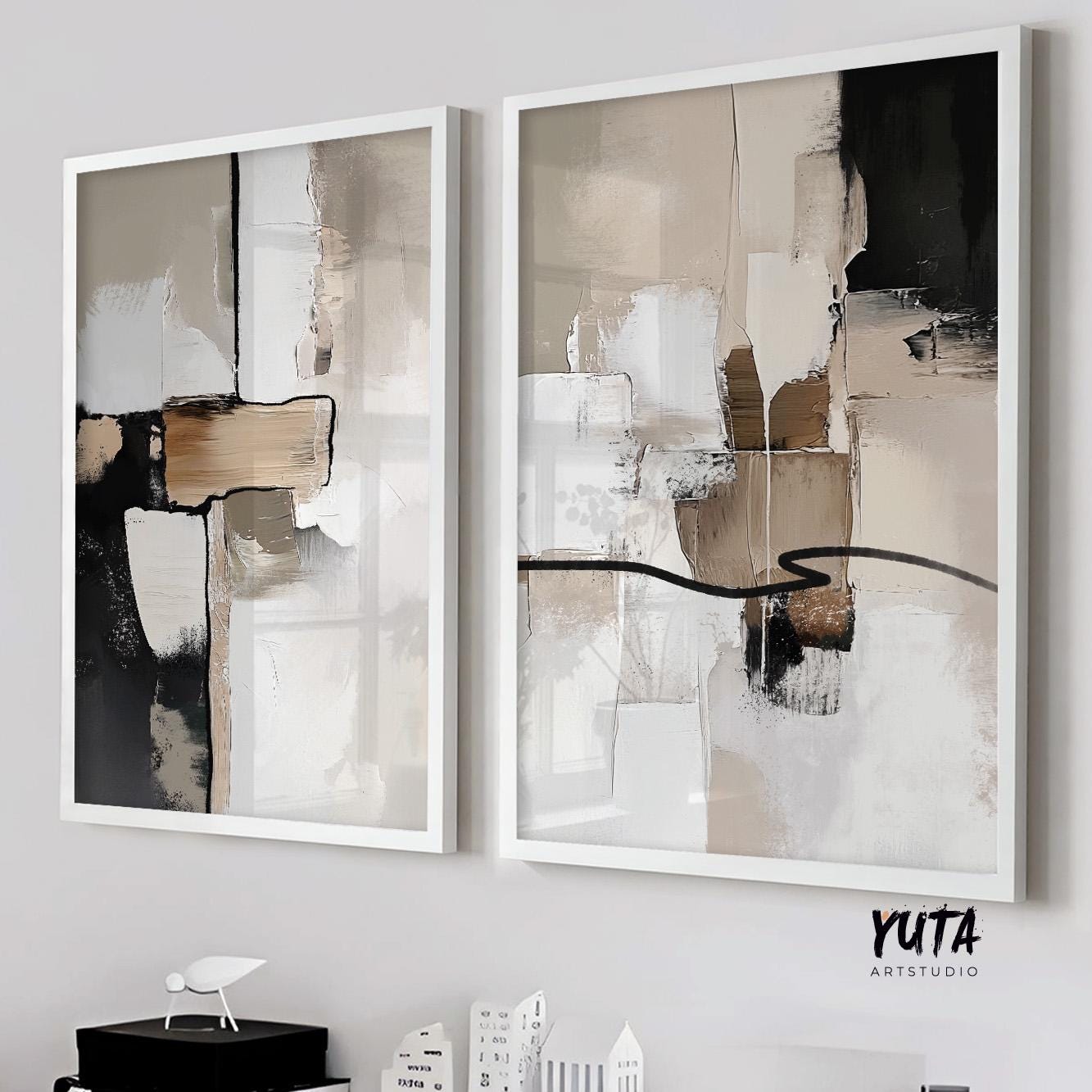 Two neutral abstract brushstroke prints with geometric forms in white frames, hung side by side.