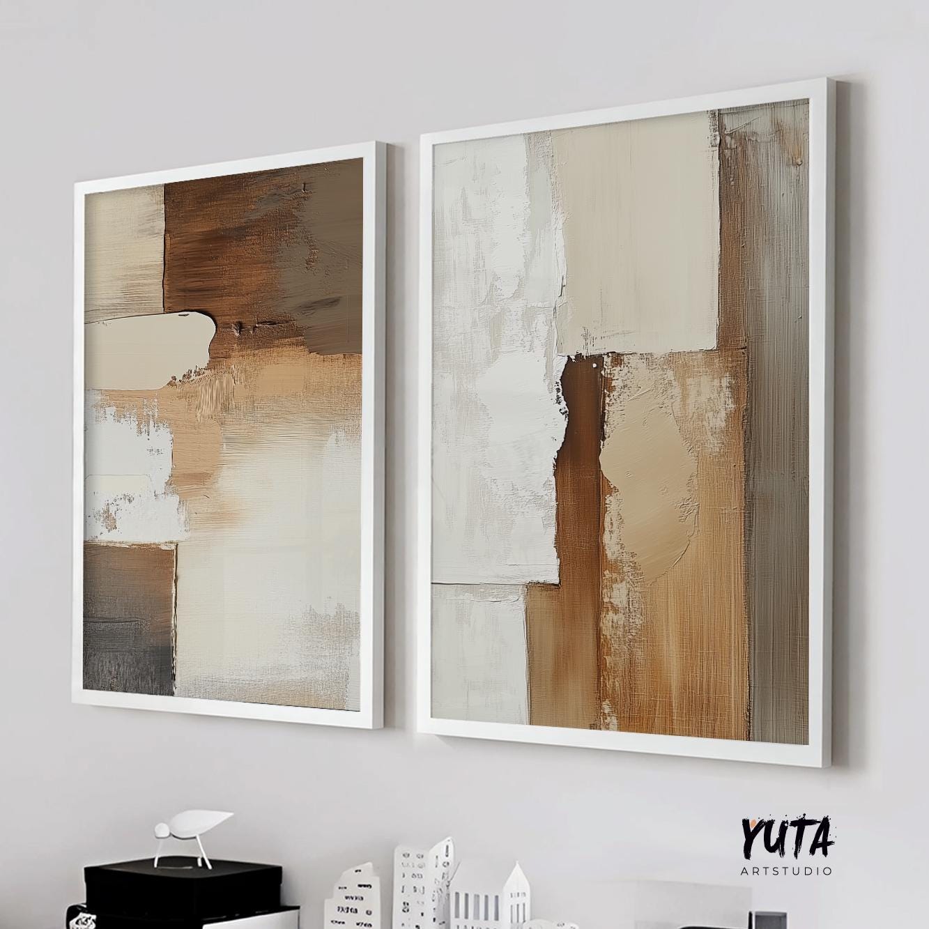 Two framed neutral abstract paintings in beige and brown tones hung side by side