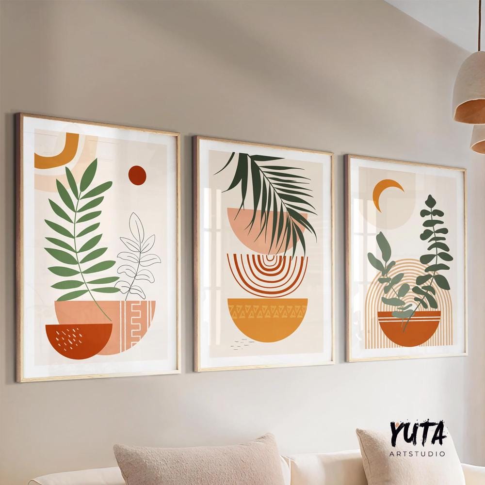Set of three framed terracotta botanical prints arranged above a neutral sofa