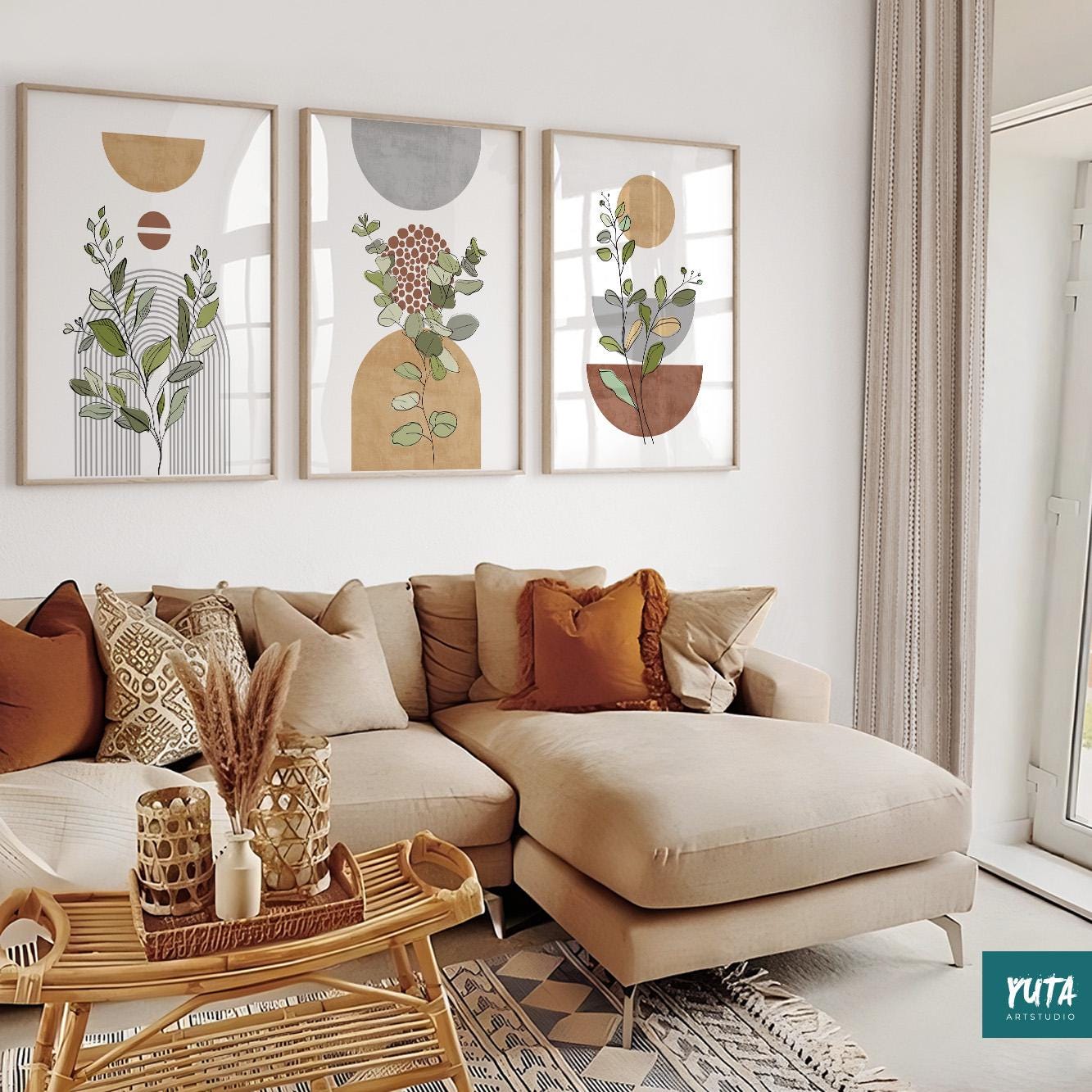 Framed boho abstract botanical prints in a trio above a sectional sofa in a bright room