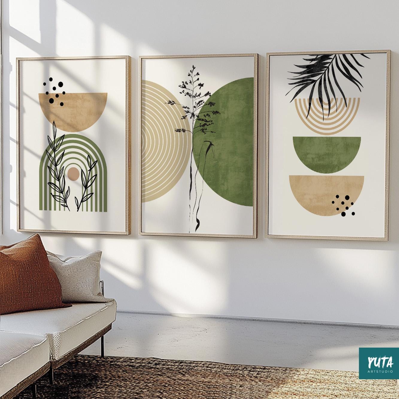 Three framed abstract prints with green and beige shapes arranged above a cream sofa.