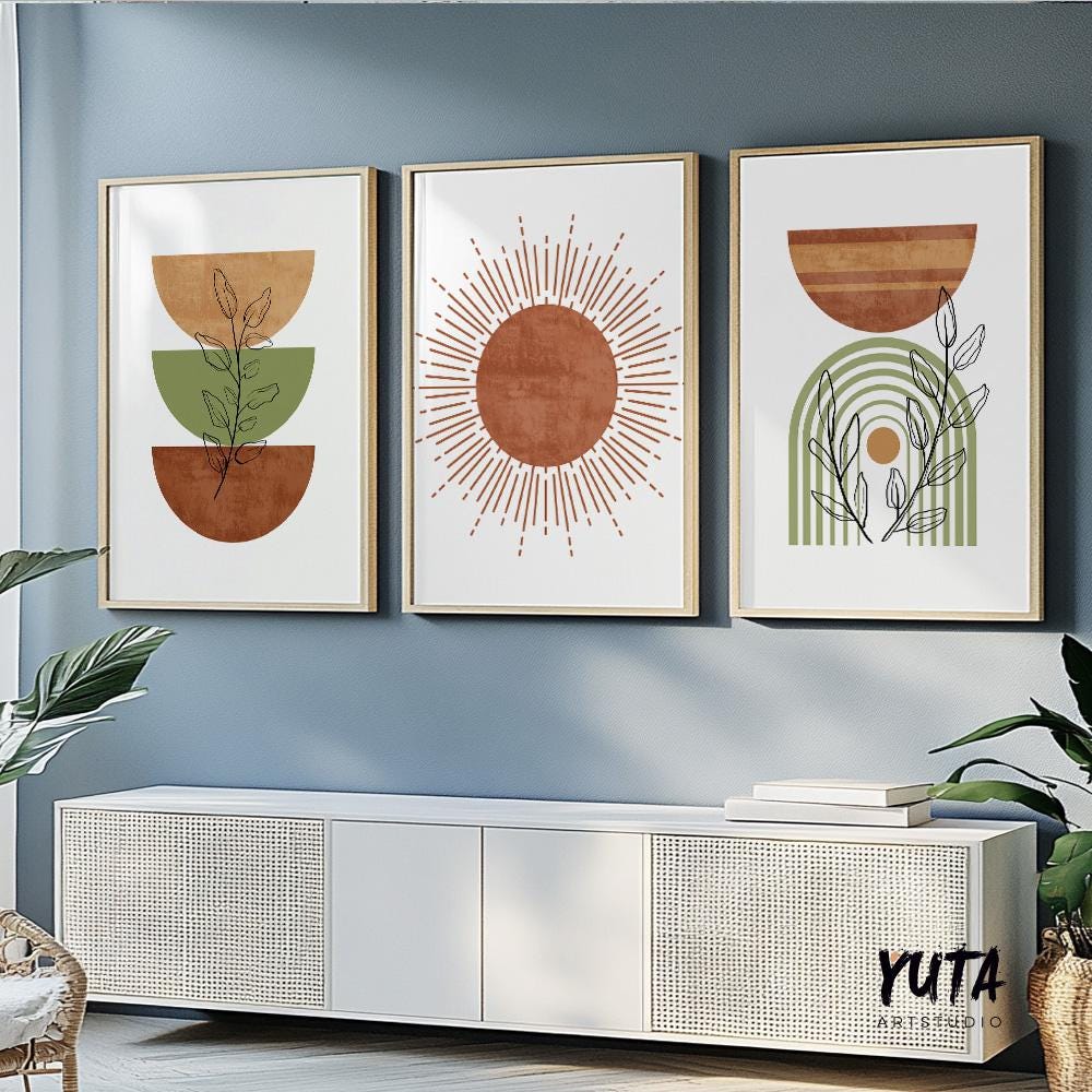 Three framed terracotta and green abstract prints in a gallery arrangement above a sideboard, illuminated by natural light.