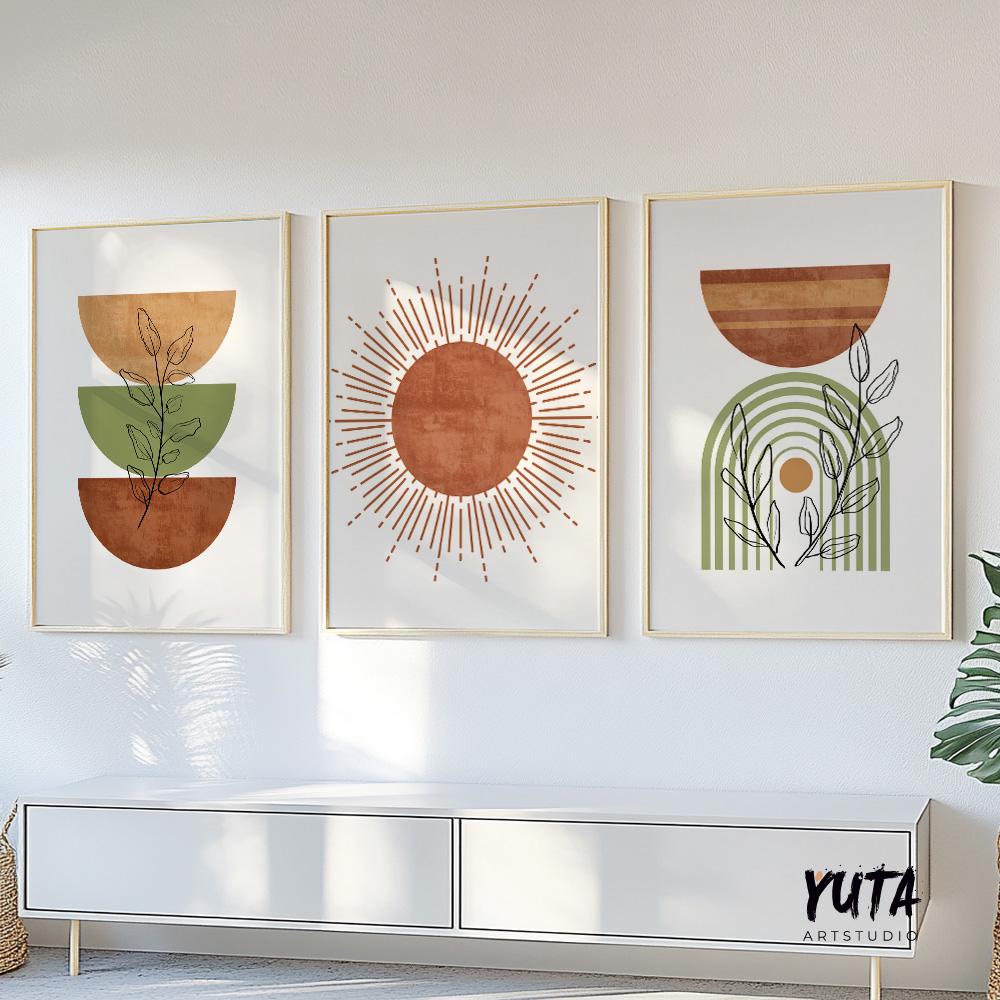 Three framed abstract boho prints with terracotta and green tones above a white console with a plant.