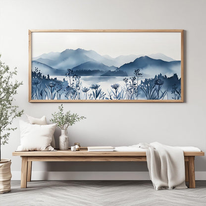 Framed navy mountain lake art with wildflowers displayed above a wooden bench