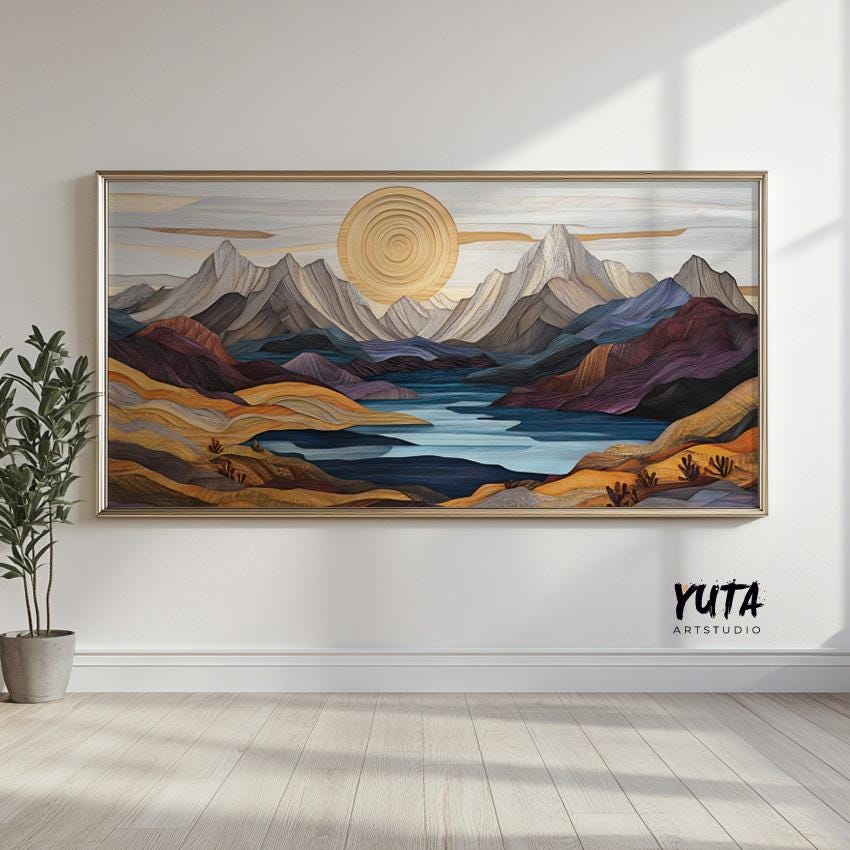 Pastel mountain landscape artwork in a silver frame, displayed on a bright wall