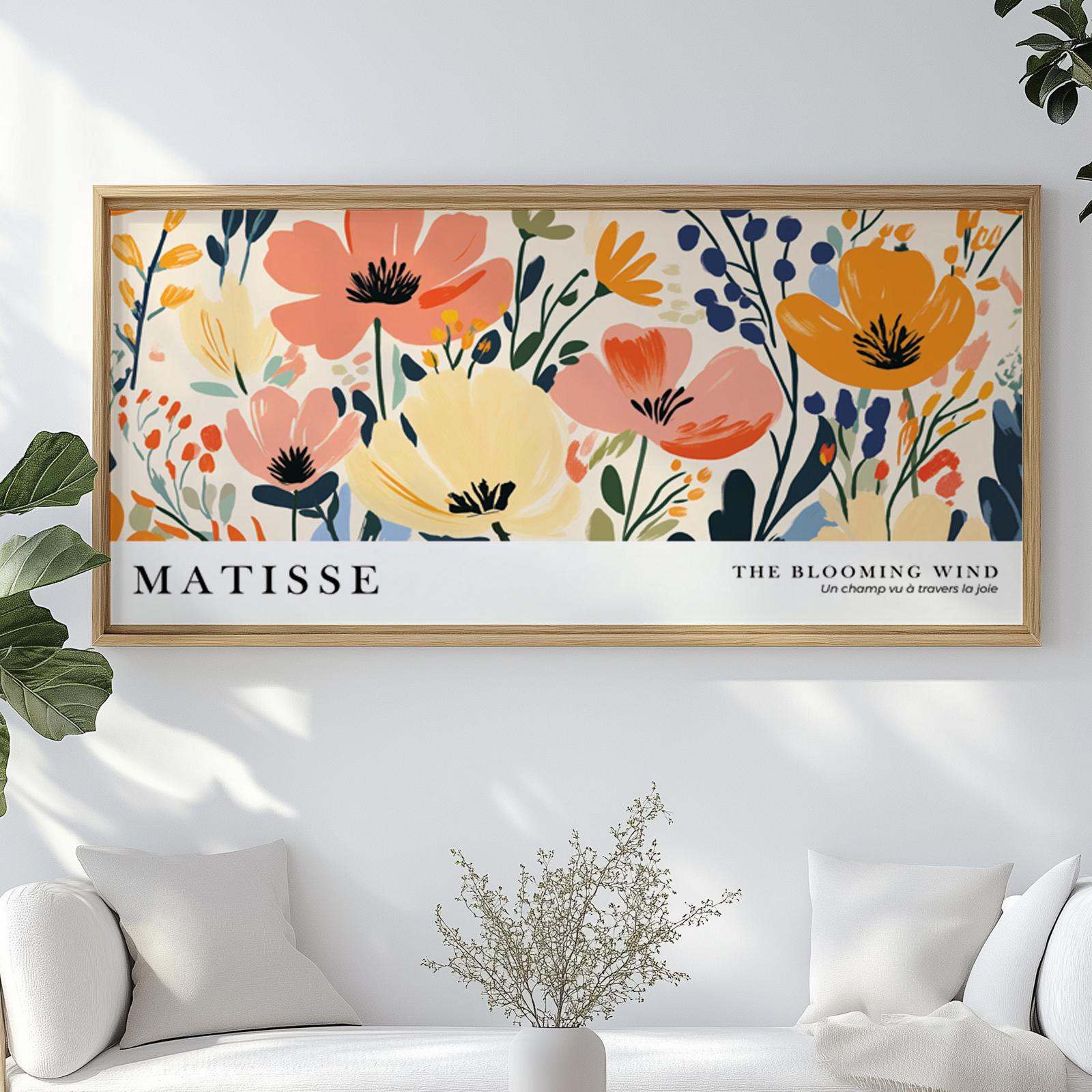 Framed Matisse-inspired floral print hanging above a white sofa in sunlit room.