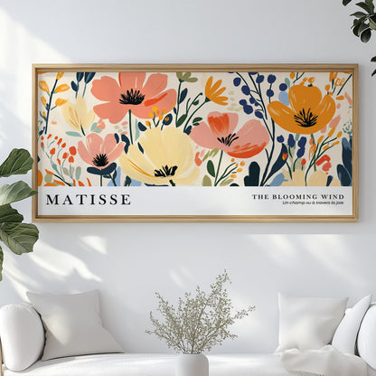 Framed Matisse-inspired floral print hanging above a white sofa in sunlit room.