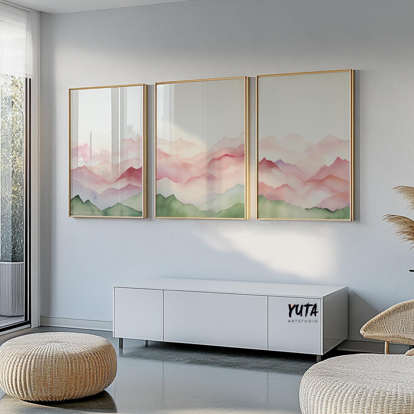 Triptych of abstract mountains in pink and green tones, framed above a white credenza with pampas grass