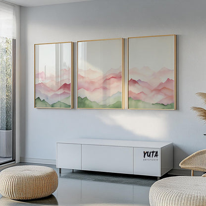 Triptych of abstract mountains in pink and green tones, framed above a white credenza with pampas grass