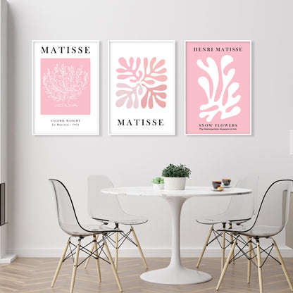 Three framed pink Matisse prints in a row above a round white table, natural daylight.