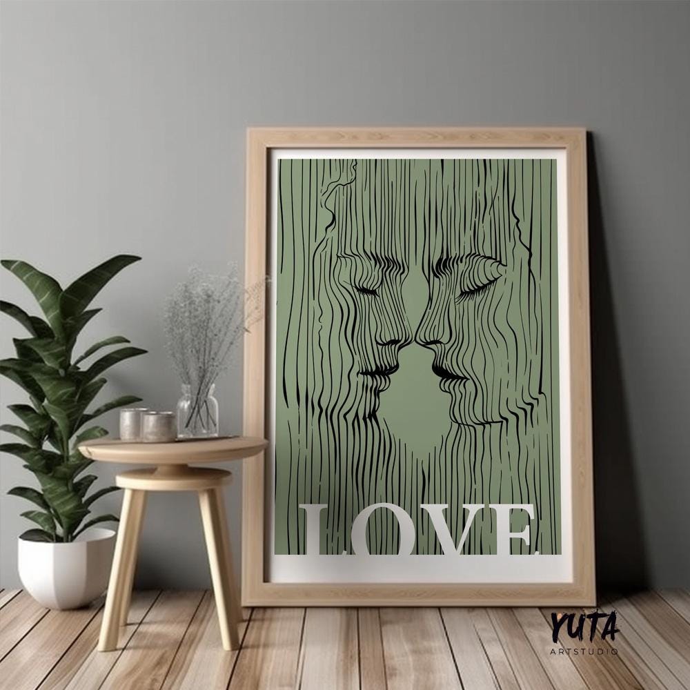 Abstract sage green lovers portrait in natural wood frame leaning against a gray wall