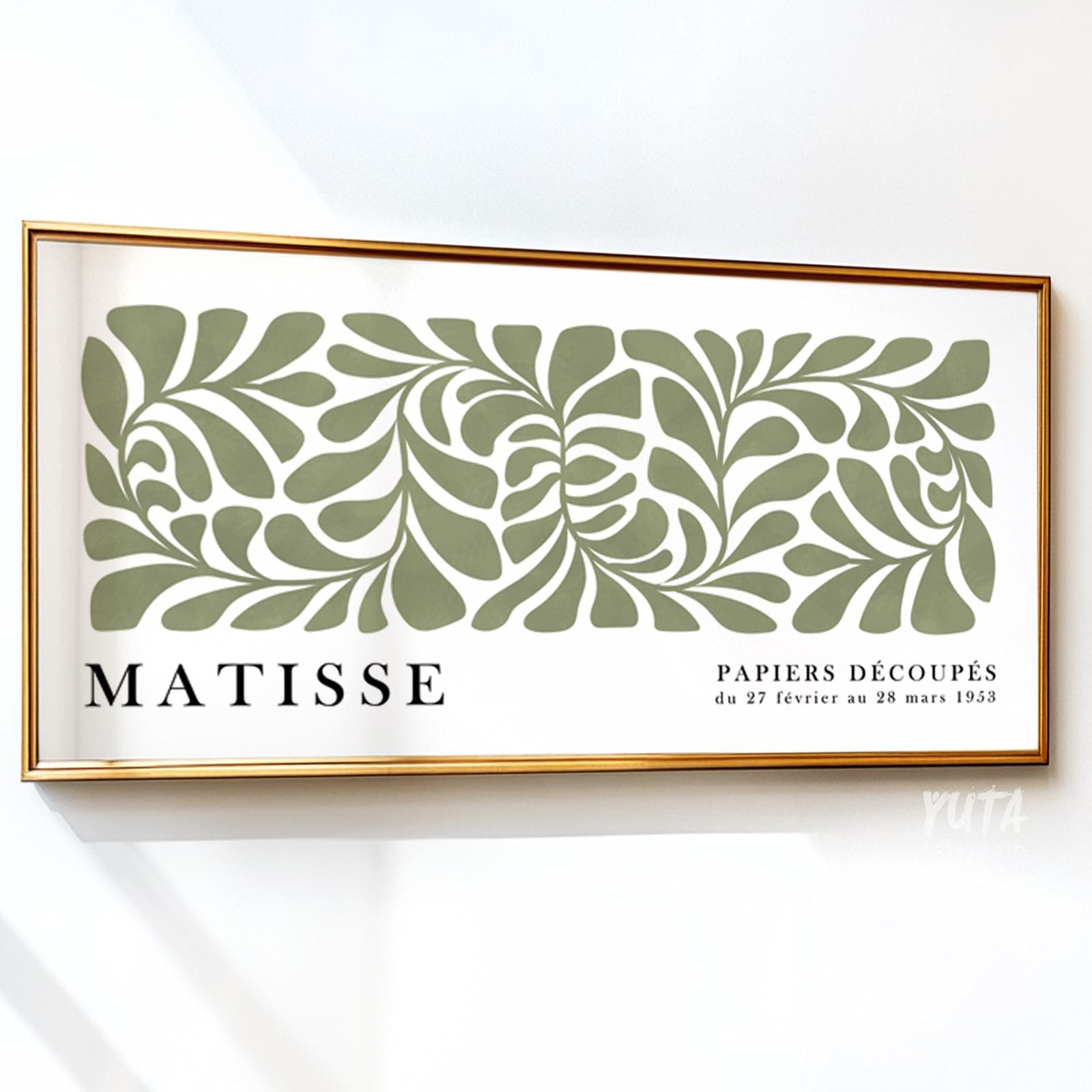Sage green abstract botanical artwork in a panoramic gold frame against a white wall