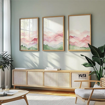 Three abstract mountain prints in natural wood frames arranged above a sideboard