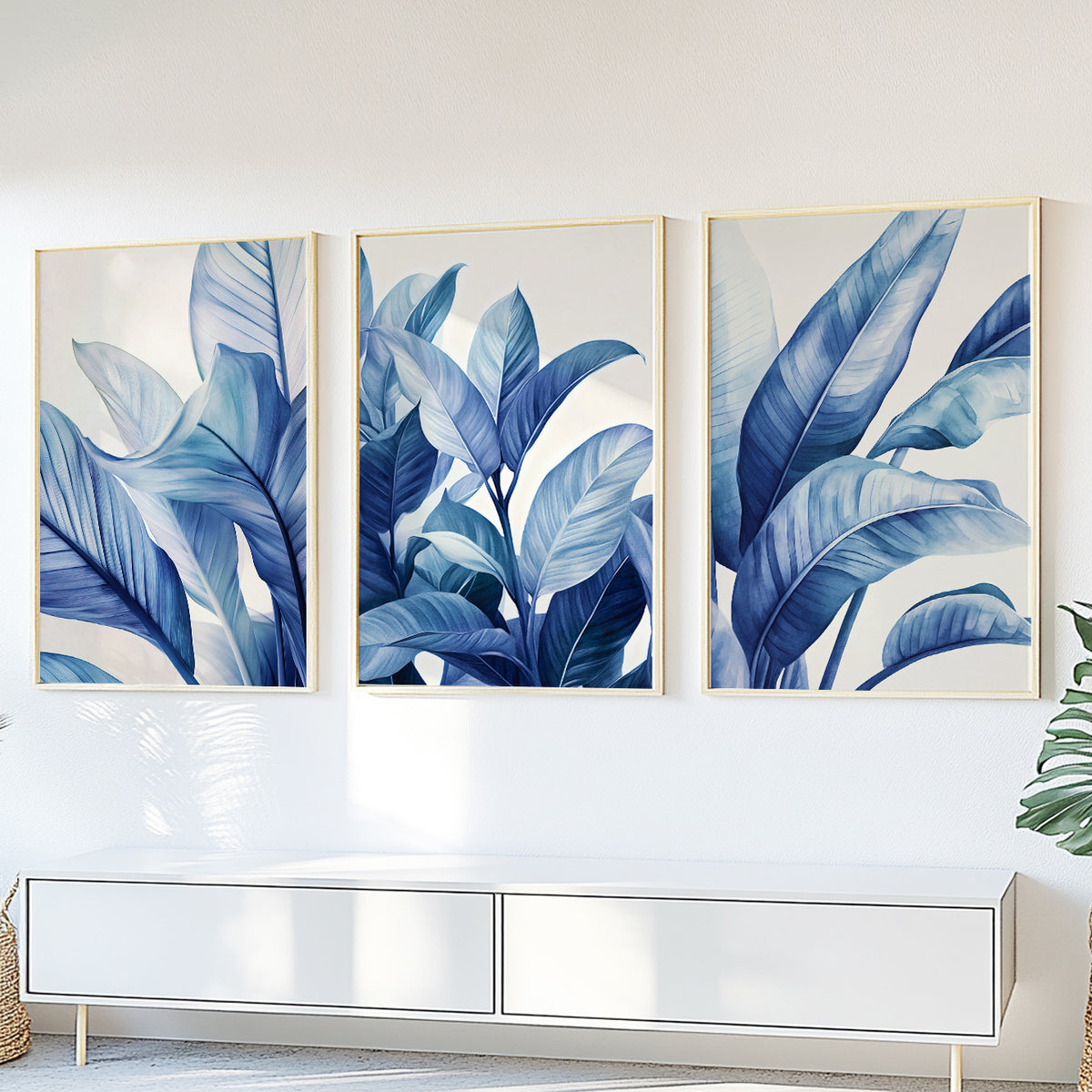 Tropical blue wall art set of 3 featuring lush botanical leaves on clean white backgrounds.