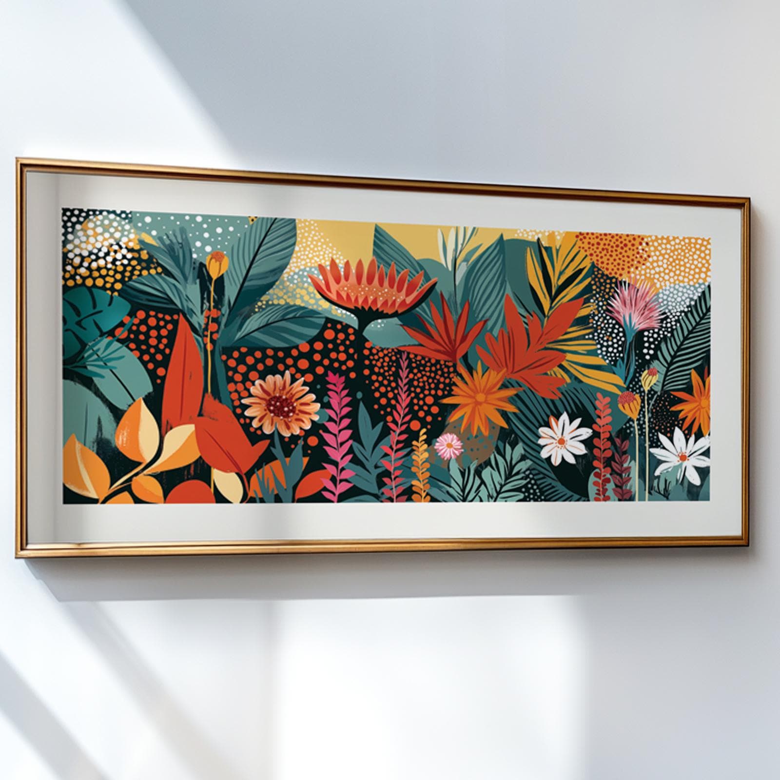 Framed abstract tropical floral artwork hung on a white wall with sunlight streaming in.