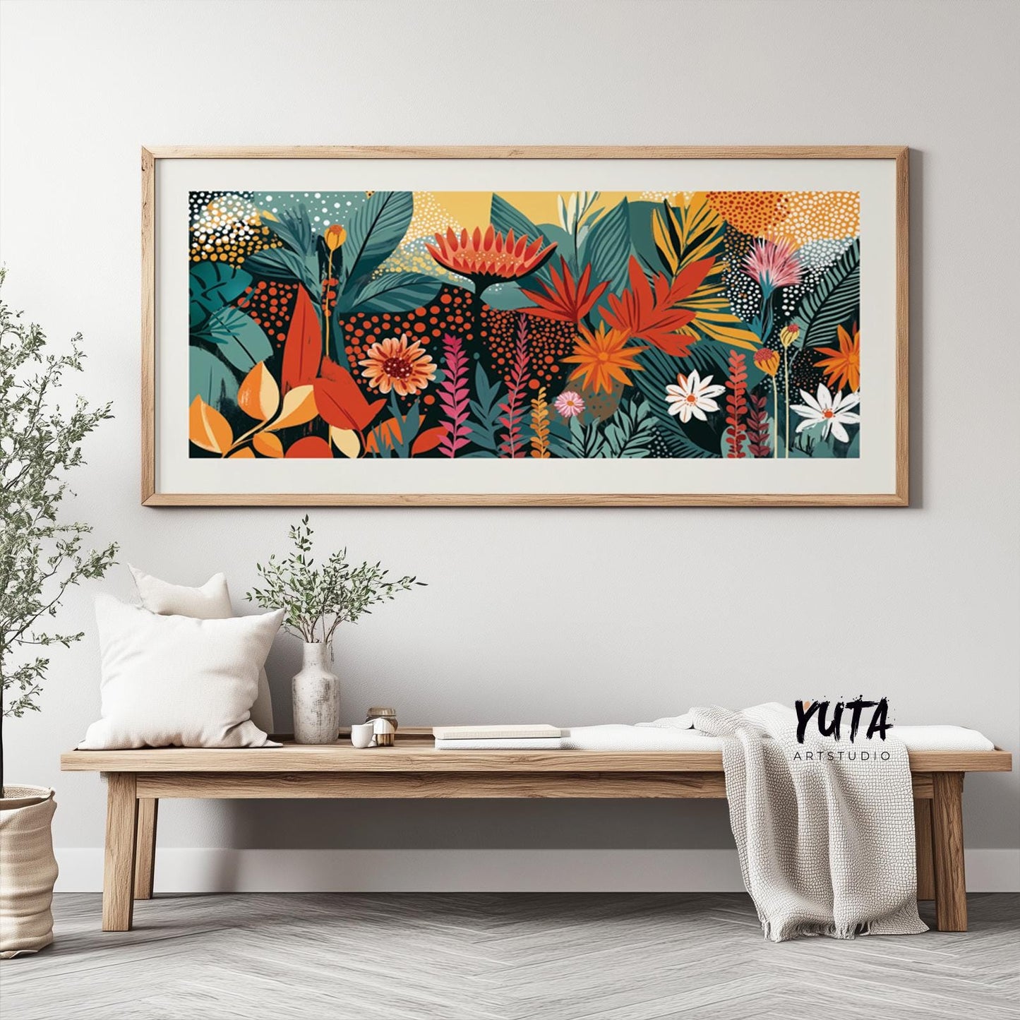 Colorful abstract tropical floral artwork in a light wood frame above a minimalist bench
