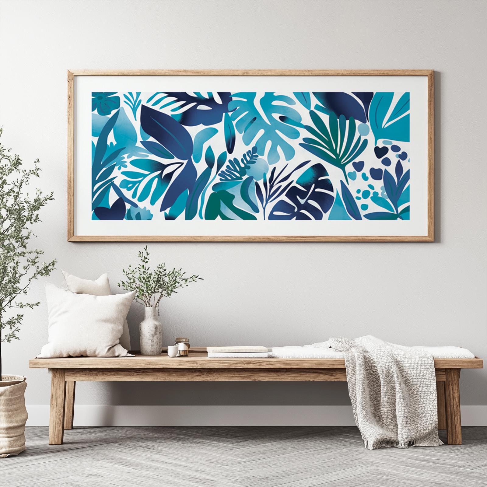 Panoramic botanical artwork with layered blue tropical leaves in a light wood frame above a bench