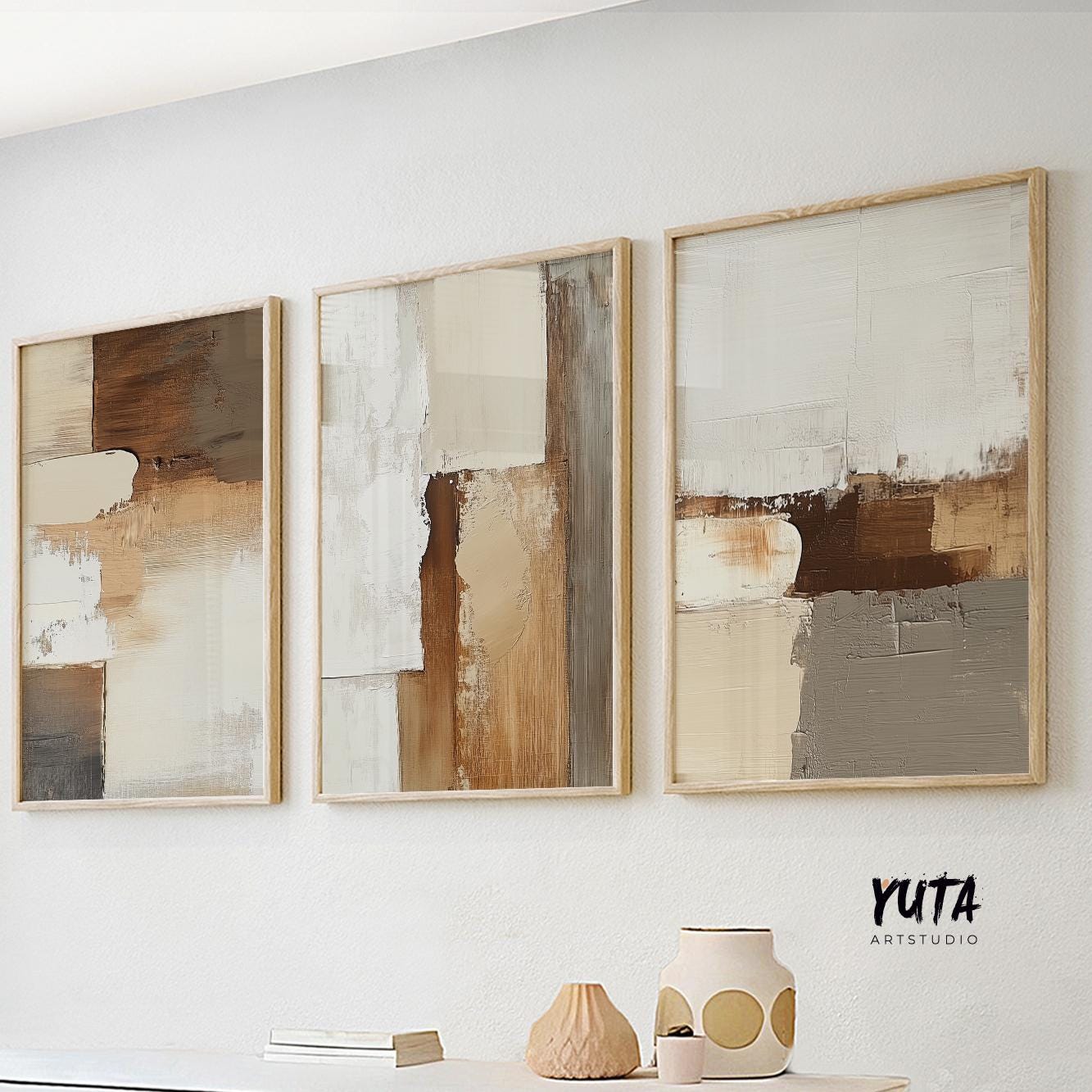Three neutral abstract prints in light wood frames, each sized 20x28 inches above a white console