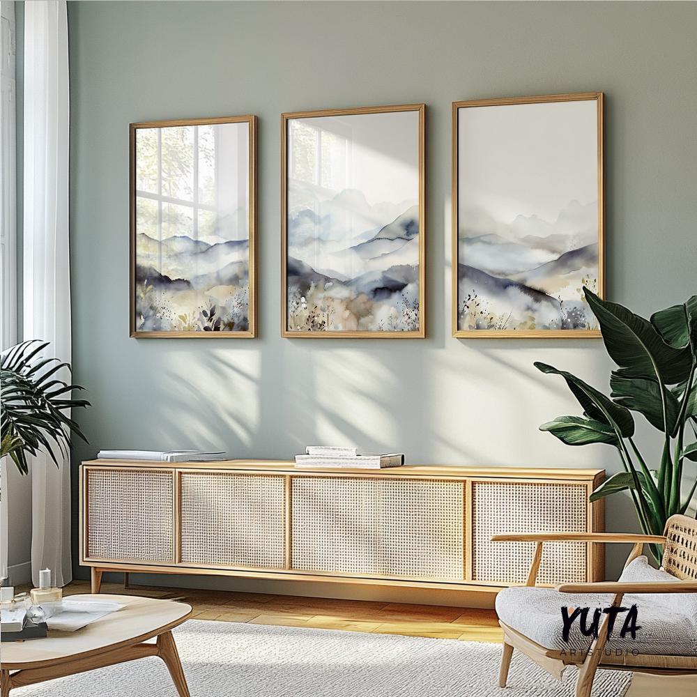Trio of minimalist mountain prints in light wood frames arranged above a sideboard.