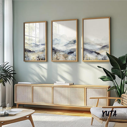 Trio of minimalist mountain prints in light wood frames arranged above a sideboard.