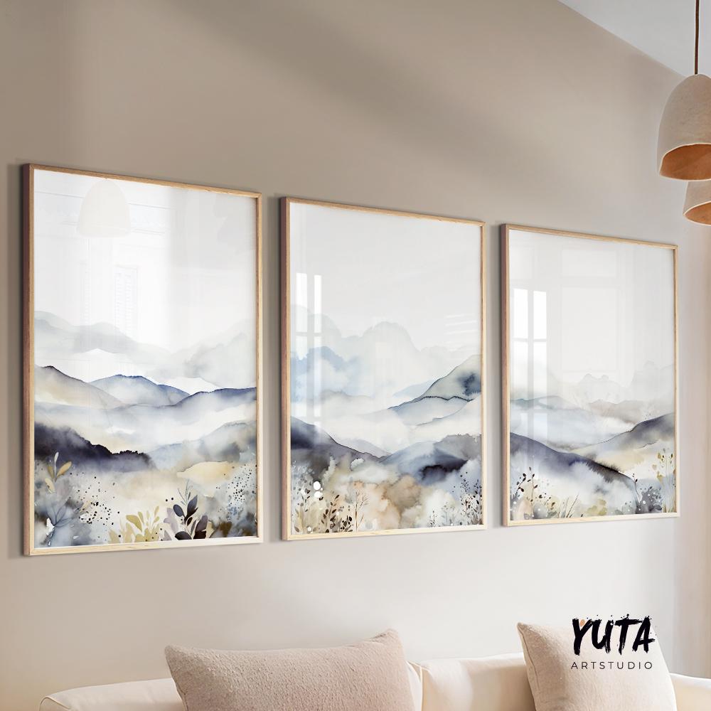 Watercolor mountain triptych in natural wood frames displayed above a cream couch