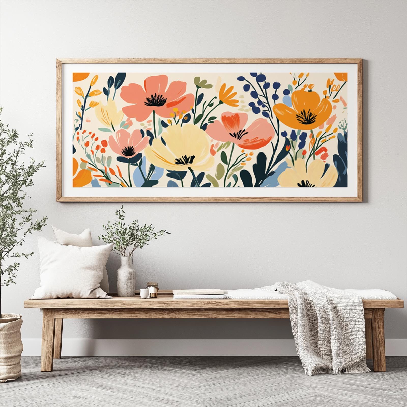 Panoramic abstract wildflower artwork in a light wood frame, displayed in natural daylight
