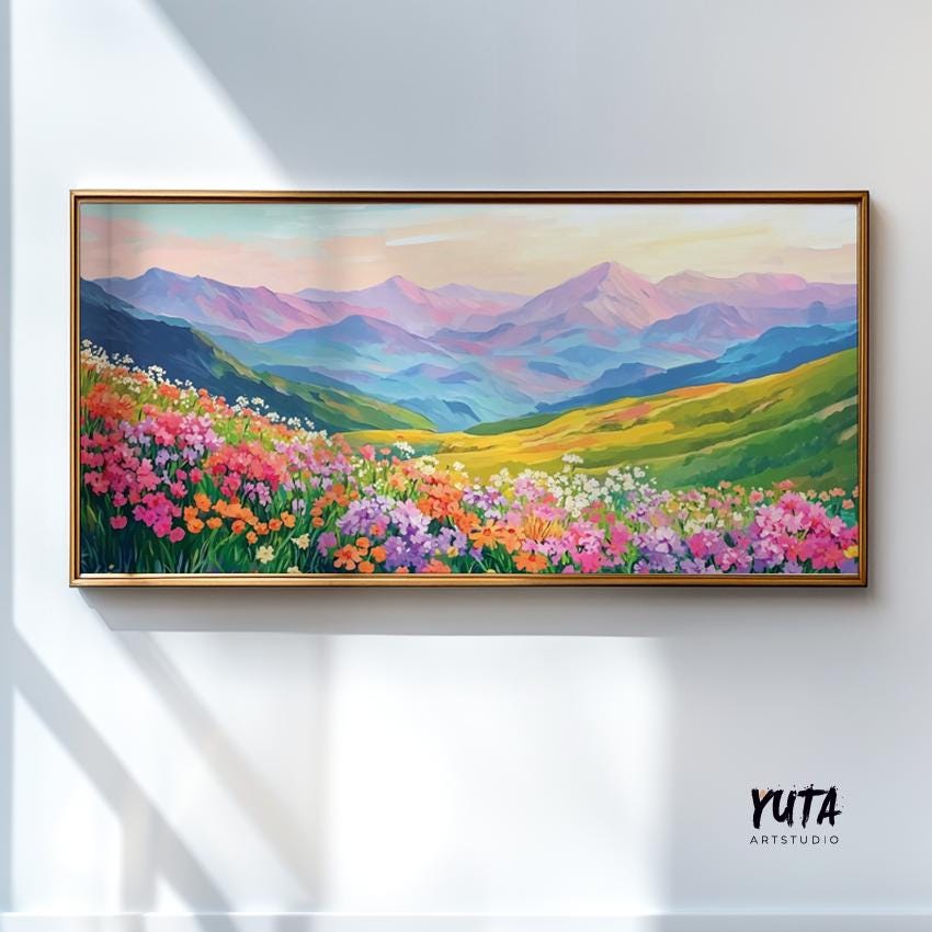 Vibrant wildflower and mountain landscape painting in a light wood frame on a sunlit wall