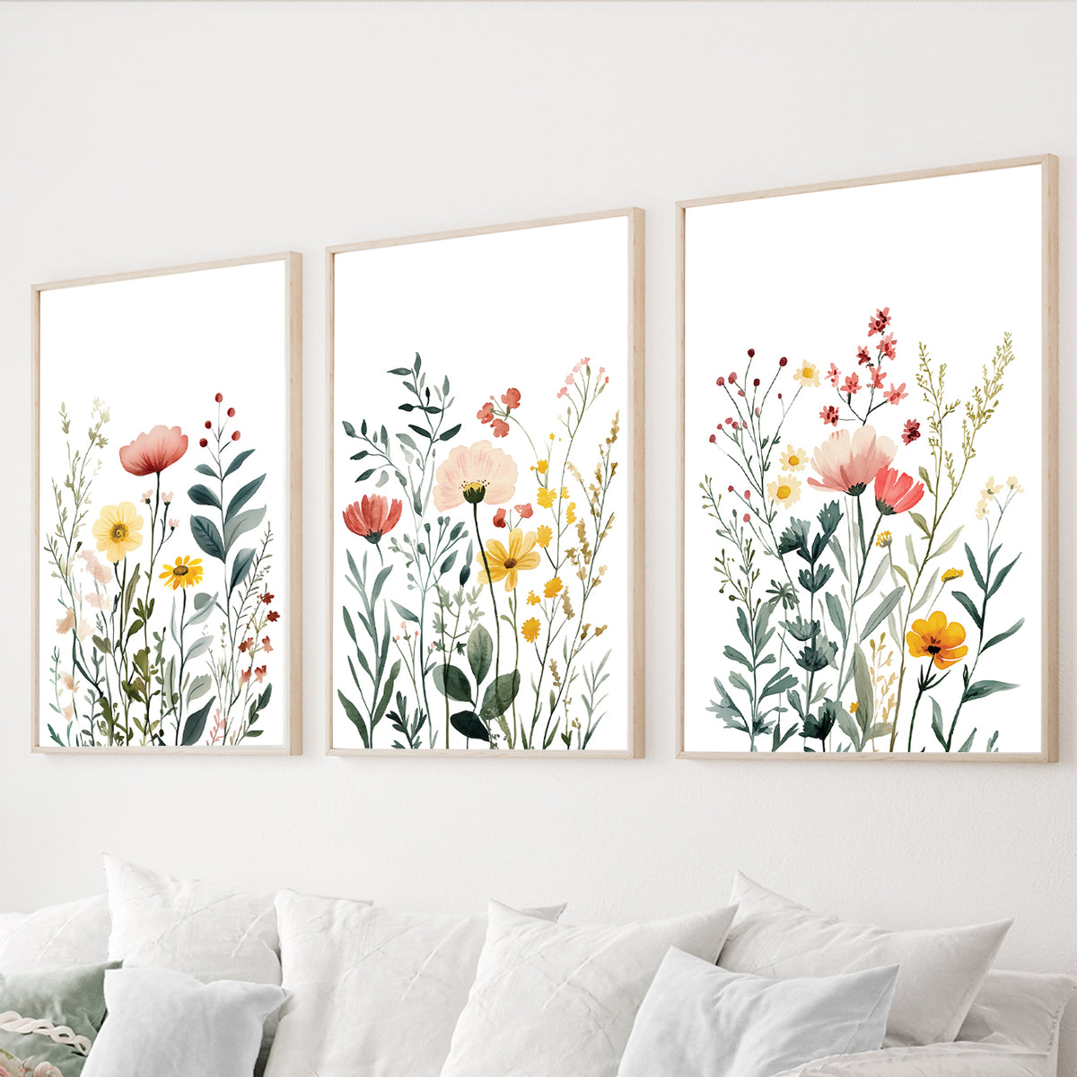 Wildflower wall art set of 3 featuring delicate watercolor meadow flowers in coral, yellow and green on white backgrounds.