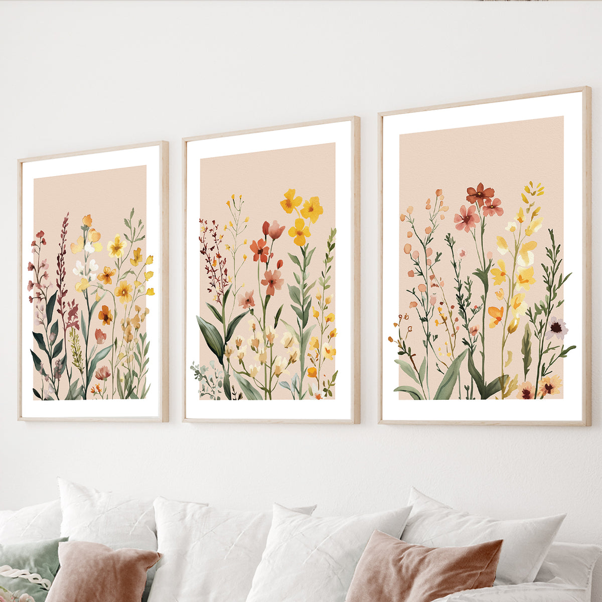 Wildflower wall art set of 3 featuring delicate watercolor meadow flowers in warm yellow, blush, rust and green tones.